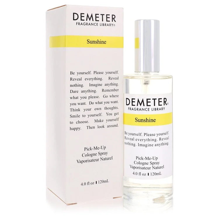 Minimalist clear glass bottle of Demeter Sunshine cologne spray illuminated by glowing golden hour sunlight on an elegant marble window sill landscape.