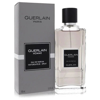 Guerlain Homme Cologne by Guerlain sleek glass bottle revealing the crisp woody aromatic fragrance liquid inside, resting on a clean minimalist surface