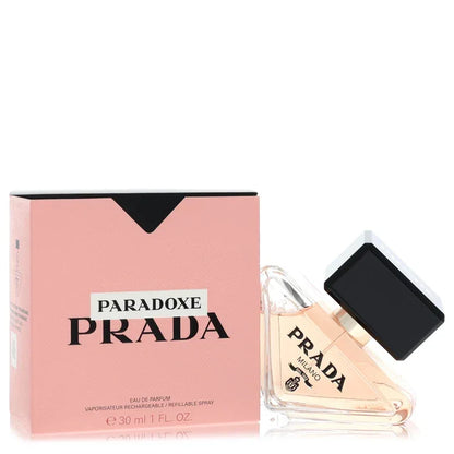 Prada Paradoxe Perfume signature luxury diamond-shaped triangular architectural glass flacon resting tilted displaying delicate pink fluid tones, styled with bold black contrast brand typographic markings, and topped with an elegant glossy black cylindrical collar closure detail against a solid backdrop