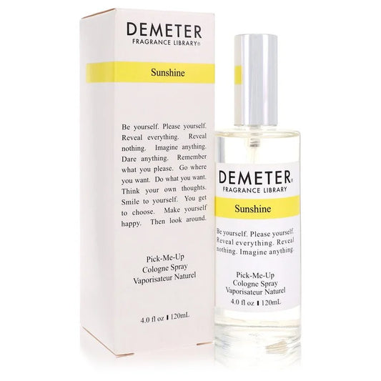 Minimalist clear glass bottle of Demeter Sunshine cologne spray illuminated by glowing golden hour sunlight on an elegant marble window sill landscape.