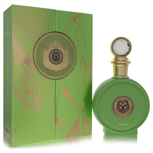 Green perfume bottle with gold accents and decorative packaging on a white background