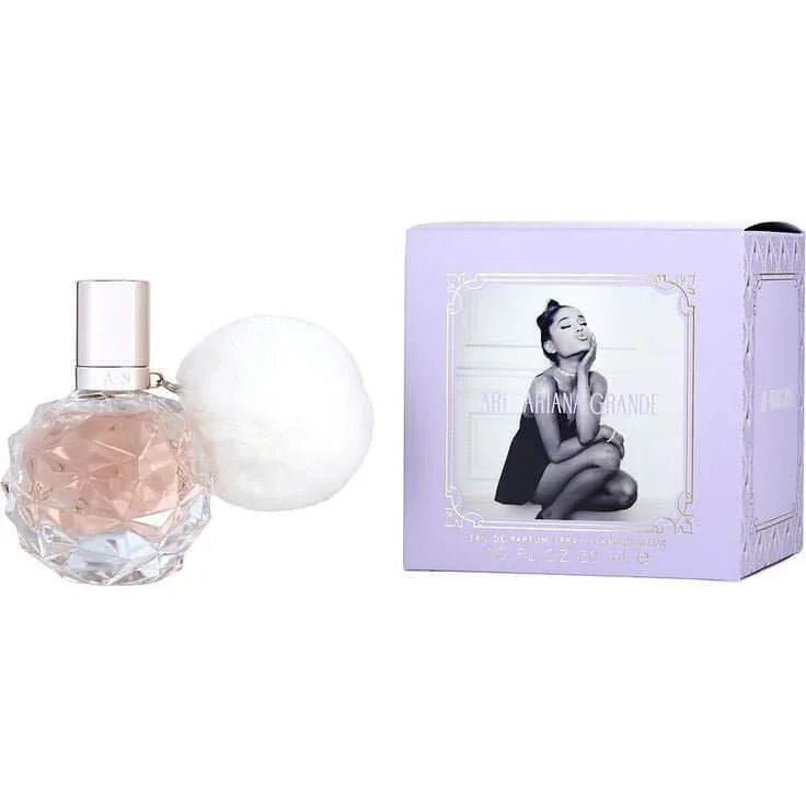 Ariana Grande Ari Eau de Parfum elegant clear gem-faceted perfume bottle with signature white plush pom-pom — luxurious floral fruity gourmand fragrance featuring raspberry, pear, grapefruit, and marshmallow notes